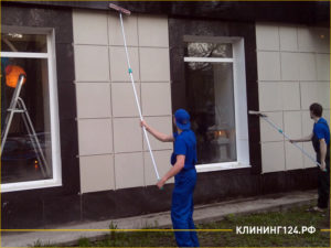 Специалисты чистят фасад магазина в центре города
